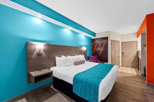 a hotel room with a bed and a blue wall at Howard Johnson by Wyndham Jackson in Jackson