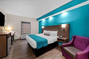 a hotel room with a bed and a chair at Howard Johnson by Wyndham Jackson in Jackson