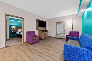 a living room with a couch and two chairs at Howard Johnson by Wyndham Jackson in Jackson