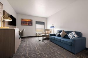 un salon avec un canapé bleu et une télévision dans l'établissement La Quinta by Wyndham Ft. Worth - Forest Hill, TX, à Forest Hill