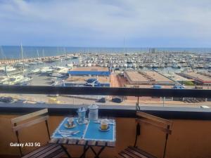 balcone con tavolo e vista su un porto turistico. di La Suite Sinatra a Nettuno
