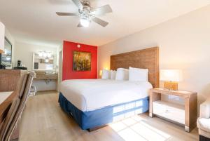 a bedroom with a large bed with a red wall at Ramada by Wyndham Flamingo Water Park in Kissimmee