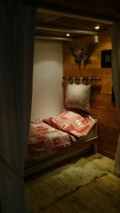 a bedroom with a bed with a wooden wall at Chalet Espace Lumière - Spa, sauna et salle de fitness in Méolans +172 photos