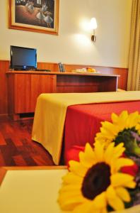 una camera d'albergo con un tavolo con un girasole di B&B Hotels HOTEL PRESTIGE ORNAGO a Ornago