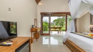 a bedroom with a bed and a desk with a desk at Tenggala Villa Ubud by Mahaputra in Ubud