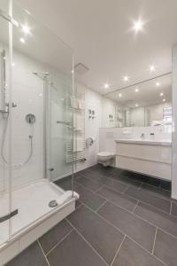 a bathroom with a shower and a toilet and a sink at Hotel Wandinger Hof by Lehmann Hotels in Markt Schwaben