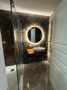 um banheiro com uma pia e um espelho em Skyline Soak, Views & Jacuzzi em St Julian's