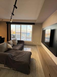 un soggiorno con un divano e una grande finestra di Skyline Soak, Views & Jacuzzi a San Giuliano