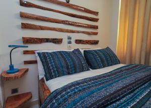 Un dormitorio con una cama con troncos en la pared. en Villa Rosa Cotonou, en Cotonou 90 fotos más
