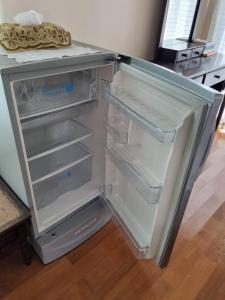 an empty refrigerator with its door open in a kitchen at บ้านชยชิโต Chayachito Home Stay in Ban Mo