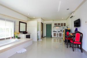a large bathroom with a tub and a table with red chairs at Naka Resort in Kamala Beach