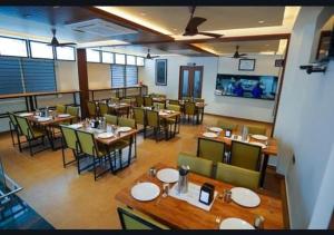 a dining room with tables and chairs in a restaurant at Hotel Harigovindas Express Mysore in Mysore
