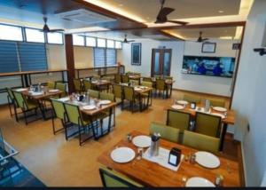 a dining room with tables and chairs in a restaurant at Hotel Harigovindas Express Mysore in Mysore +25 photos