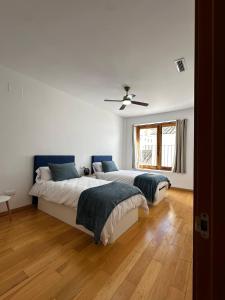 a bedroom with two beds and a ceiling fan at Casa Durá in Chulilla