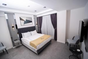 een hotelkamer met een bed, een bureau en een stoel bij Alion Hotel in Konak
