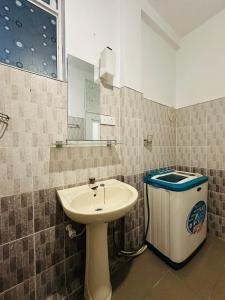 a bathroom with a sink and a trash can at Skyline Stay Guest House in Galle