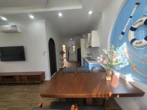 a dining room with a wooden table and a kitchen at Villa 4 bedrooms, 5 bathrooms, sea view at NovaWorld Phan Thiet 53 in Bình Tú