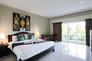 a bedroom with a large bed and a balcony at Naka Resort in Kamala Beach +59 photos