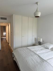 a white bedroom with a bed and a white cabinet at Luxury apartment in Marseille