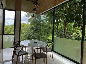 Ban Thung Pa HaeoにあるStarry Hill House Chiangmai - บ้านสวนชมดาวの窓のあるベランダ(テーブル、椅子付)