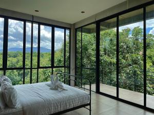 Ban Thung Pa HaeoにあるStarry Hill House Chiangmai - บ้านสวนชมดาวのベッドルーム1室(ベッド1台、大きなガラス窓付)