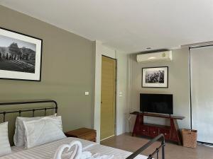 Ban Thung Pa HaeoにあるStarry Hill House Chiangmai - บ้านสวนชมดาวのベッドと薄型テレビのある寝室