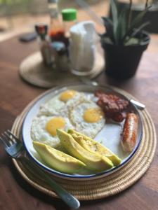 a plate of breakfast food with eggs and a sausage at Hemingway's Luxury Tented Camp in Paraa