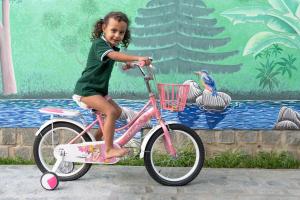 a little girl is riding a pink bike at Villa Paradis in Sainte Marie