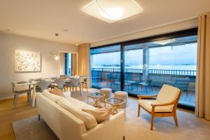 a living room with white furniture and a dining room at Ocean Pearl Suite in Kuningatarranta Hanko in Hanko
