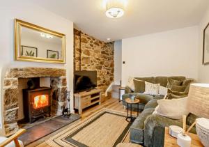 a living room with a couch and a fireplace at Ty Fin Cottage with Hot Tub in Llanbedrog