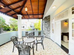 a patio with a table and chairs and a couch at Blue Moon Villa in Weligama