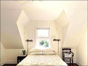 ein Schlafzimmer mit einem großen Bett mit Fenster in der Unterkunft Shelter Island Hidden Estate in East Marion