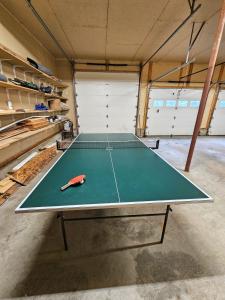 a ping pong table in the middle of a garage at River Retreat with Hot Tub in Bethel