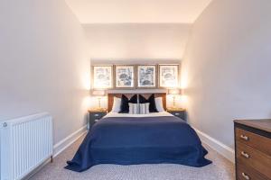 Un dormitorio con una cama con dos mesitas de noche y dos lámparas. en Taigh Carnan, en Inverness