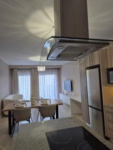 ヨハネスブルグにあるCorporate Luxury - Sandton, Rivoniaのテーブルと冷蔵庫のあるキッチンとダイニングルーム