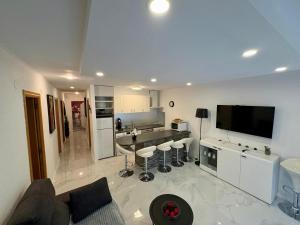 a living room with a couch and a kitchen with a tv at chez Chantal zone touristique garage gratuit in Salou