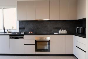 a kitchen with white cabinets and an oven at Delightful 1st Floor Xanthippis Apartment in Strovolos