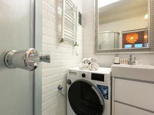 a washing machine in a bathroom next to a sink at Rooftop Studio In the heart of Bucharest w Netflix in Bucharest