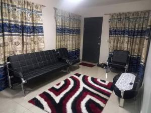 a living room with a couch and two chairs and a rug at Alis 786 apartment in Lautoka