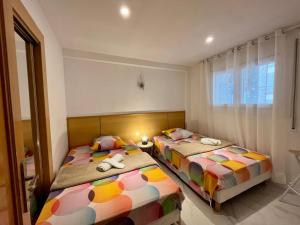 two twin beds in a room with a window at chez Chantal zone touristique garage gratuit in Salou