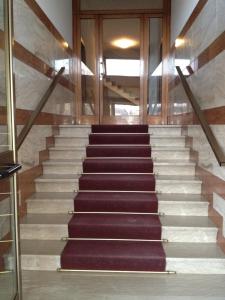 een trap in een gebouw met paars tapijt bij In Fiera 14 Apartment in Bologna