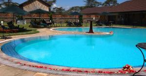 een groot zwembad met blauw water in een resort bij Sawela Lodges in Naivasha