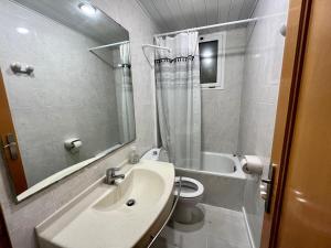 a bathroom with a sink and a toilet and a mirror at chez Chantal zone touristique garage gratuit in Salou +51 photos