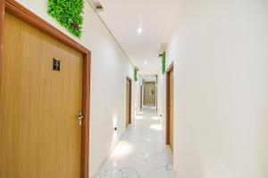a corridor of corridors with doors and plants on the walls at FabHotel Kavya Inn - Nr The Mall of Faridabad in Faridabad