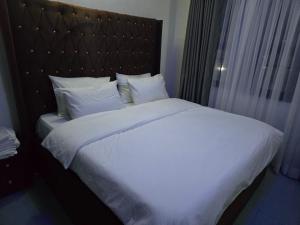 a large bed with white sheets and pillows at Life Apartment in Aguda