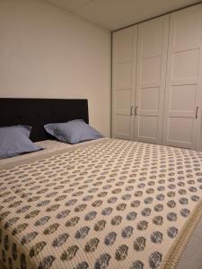 a bedroom with a bed with a comforter on it at Moderne 2 Roms Leilighet i Hjertet av Oslo in Oslo