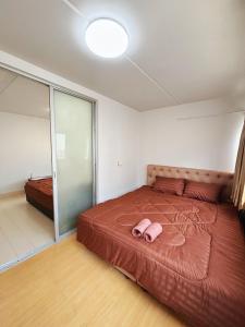 Thung Si KanにあるImpact - Don Mueng Condo C5のベッドルーム1室(ピンクのスリッパ付きのベッド1台付) +1枚の写真
