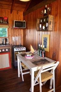 a kitchen with a table with two chairs and a stove at EntreViñas in Carmelo