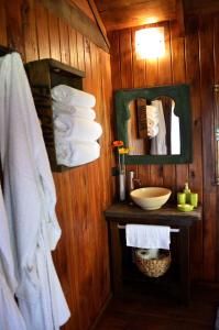een badkamer met een wastafel, een spiegel en handdoeken bij EntreViñas in Carmelo