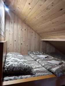 two beds in a room with wooden walls at Country Villa MMMM-3-Camp Scepanovic in Mojkovac +5 photos